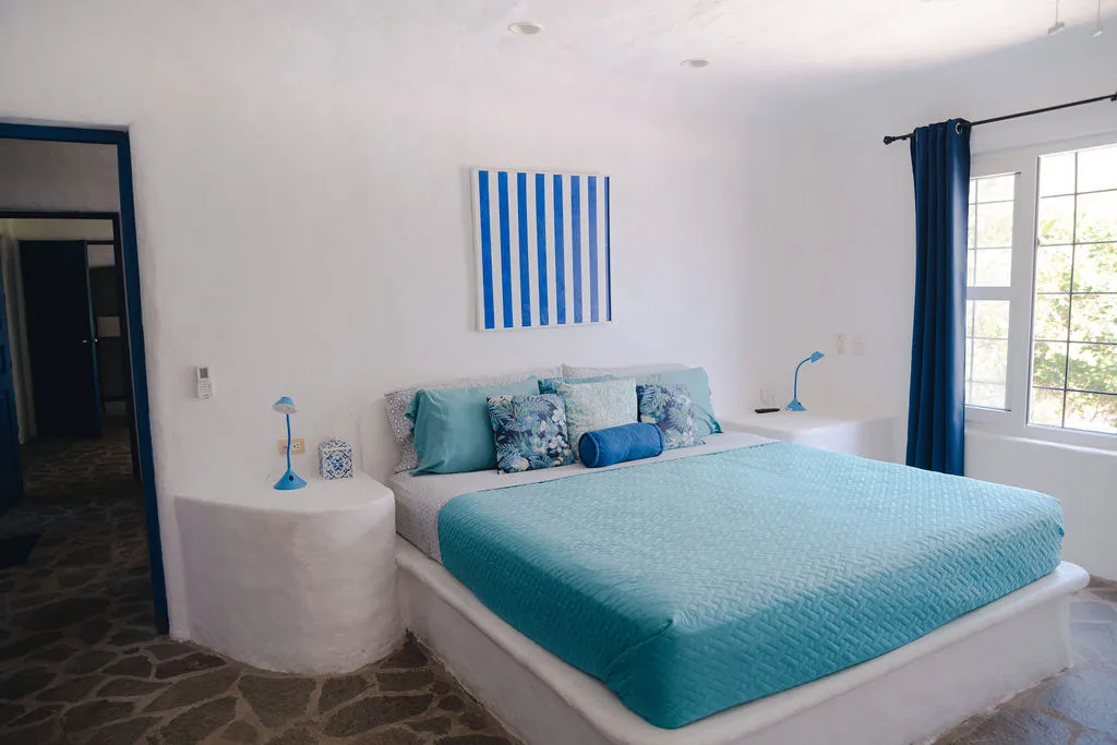 Cama turquesa con cuadro de franjas azules.