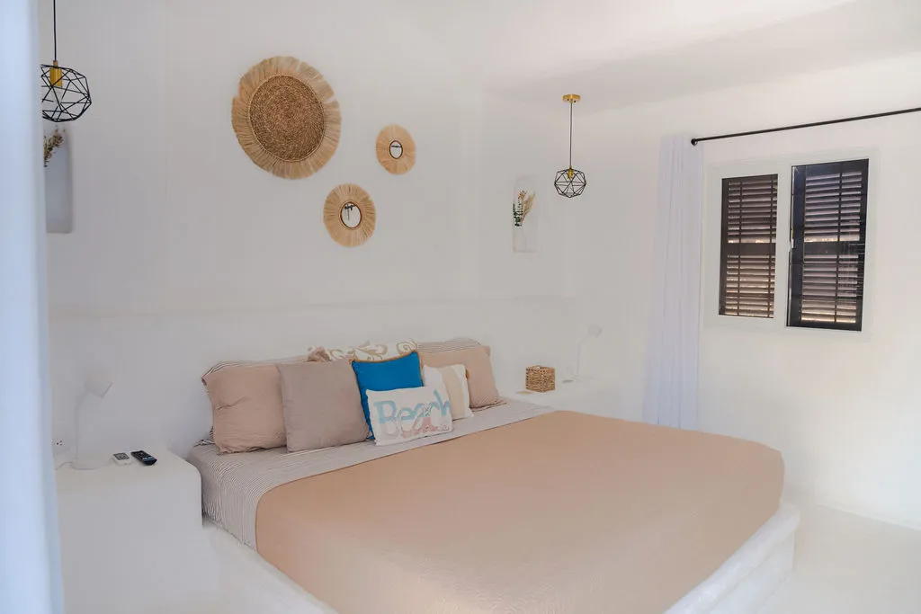 Cama beige y decoración circular tejida.