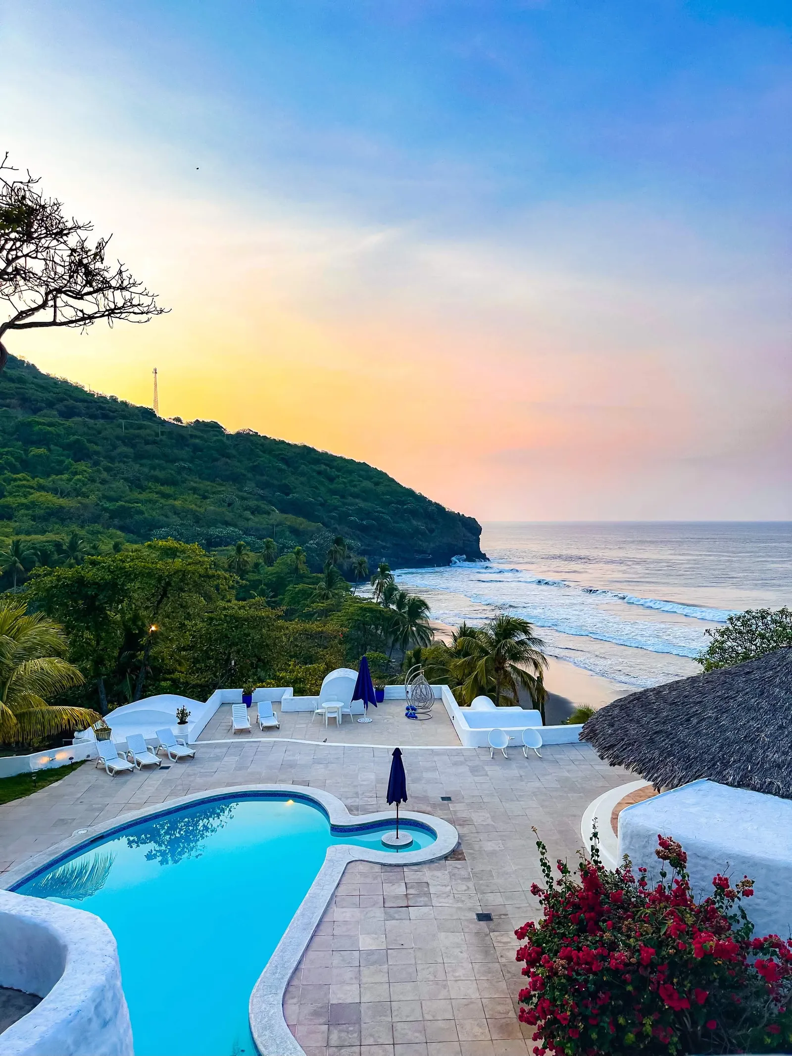 Piscina y cala bajo el cielo del atardecer.